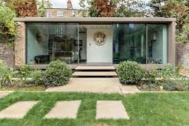 Garden Annex Extension Modern glass-fronted building with steps and landscaped garden.