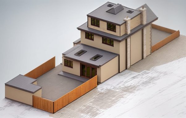 Three-storey house with a patio, wooden fence, and grey roofing.