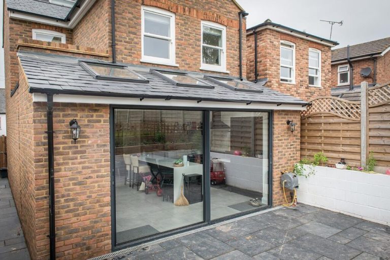 Single-Storey Rear Extension Modern brick house extension with large glass sliding doors and a patio area.