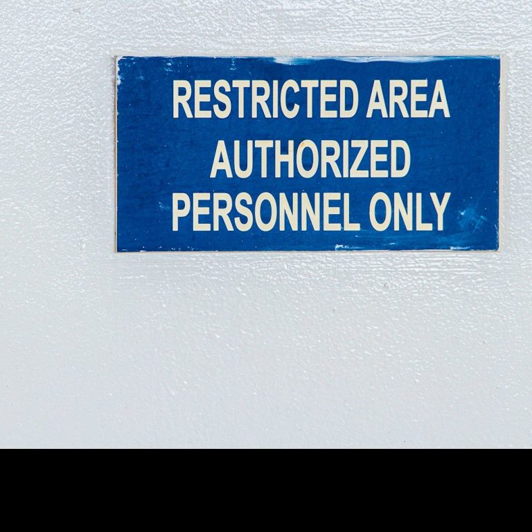 Blue sign on a wall stating "Restricted Area Authorized Personnel Only."