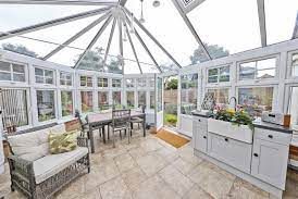 Conservatory Bright conservatory with seating, a dining table, and garden views through large windows.